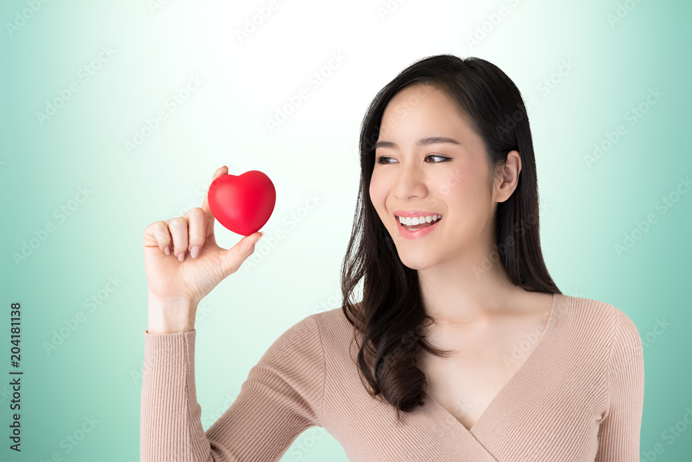 Beautiful healthy young Asian woman with red heart ball Beautiful healthy young Asian woman with red heart ball