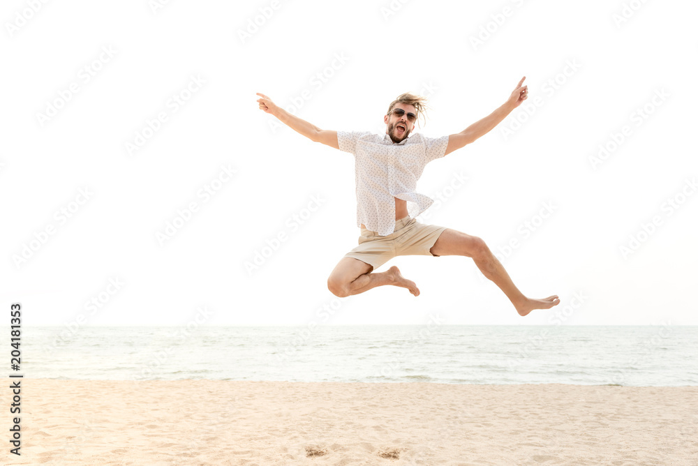 Young energetic happy man jumping at the beach Young energetic happy man jumping at the beach