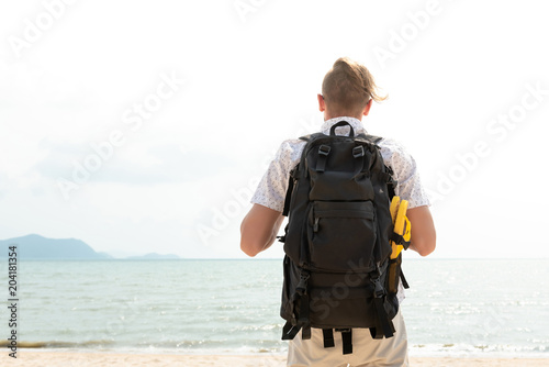 Independent young man tourist backpacker standing at the beach © Atstock Productions