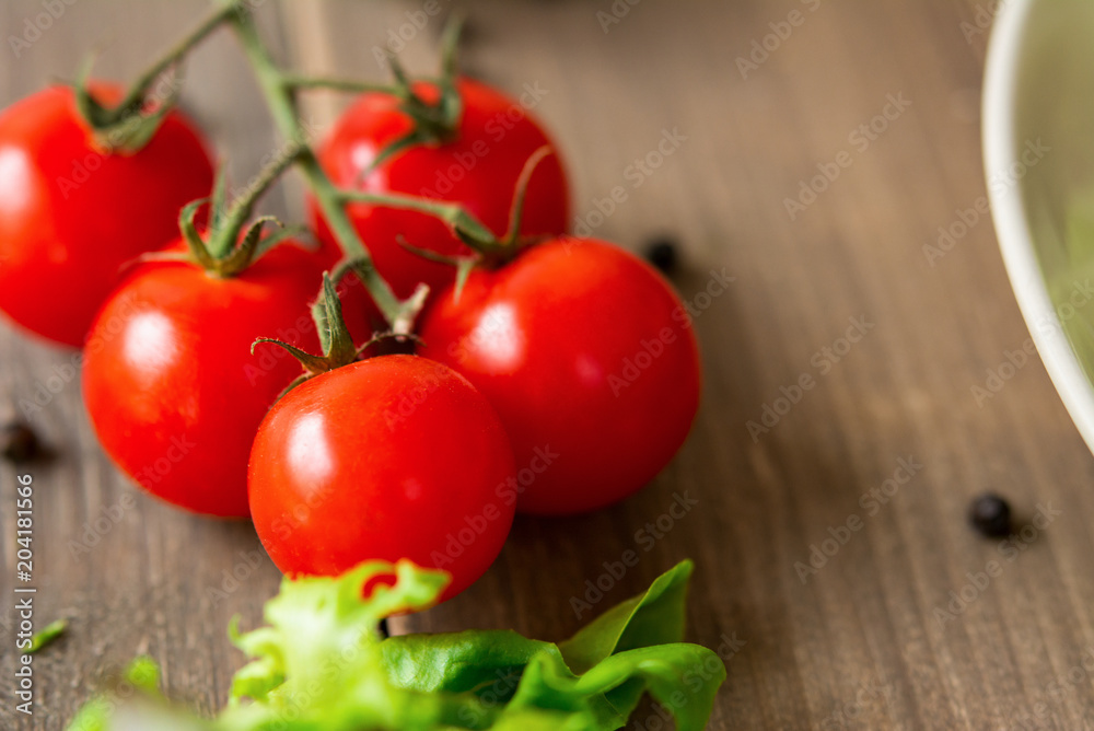 Red cherry tomato bunch on wood table Red cherry tomato bunch on wood table