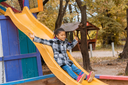 Baby girl on Playground in autumn Park.