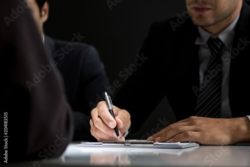 Interrogator taking note while interviewing suspect in the interrogation room