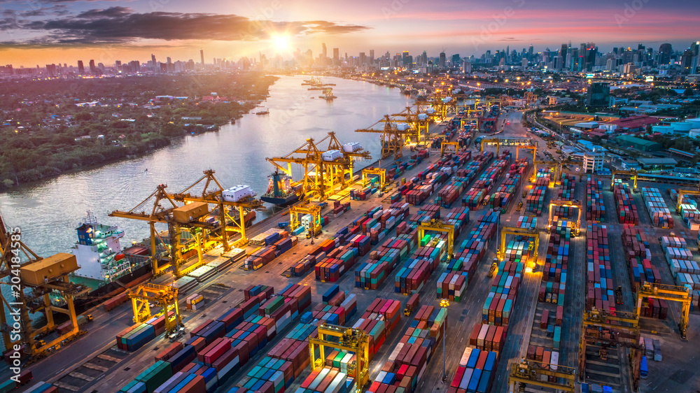 Obraz premium Logistyka i transport kontenerowca i samolotu towarowego z działającym mostem dźwigu w stoczni o wschodzie słońca, import logistyczny, eksport i transport