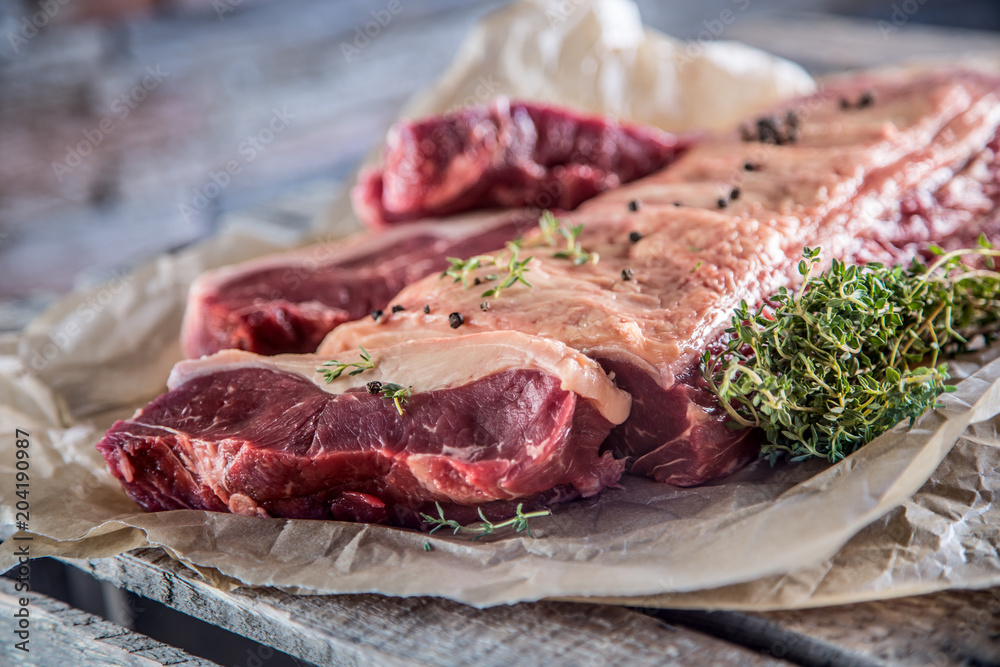 Raw rib eye beef steak with salt spices and herbs