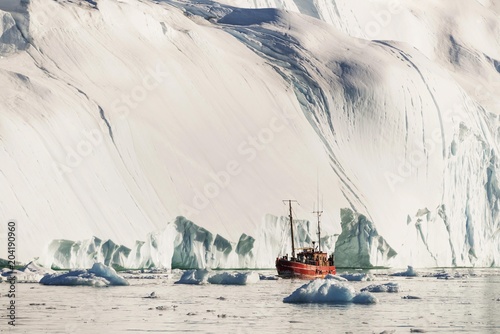 Ship in front of gigantic iceberg
