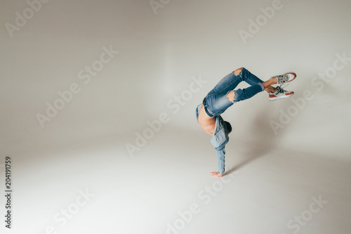 shot of jump feet up, jump, stand on one's hands, of mad, crazy, cheerful, successful, lucky guy in casual outfit, jeans, jumping with hands up,triumphant, gesturing against white background