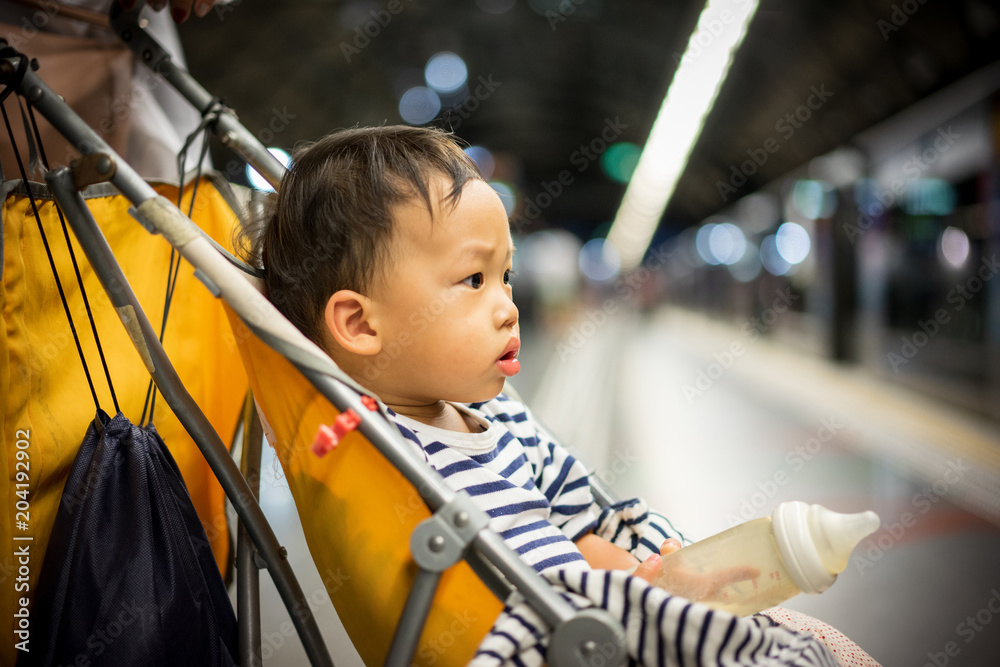 A sleepy boy waiting a train at the station. A sleepy boy waiting a train at the station.