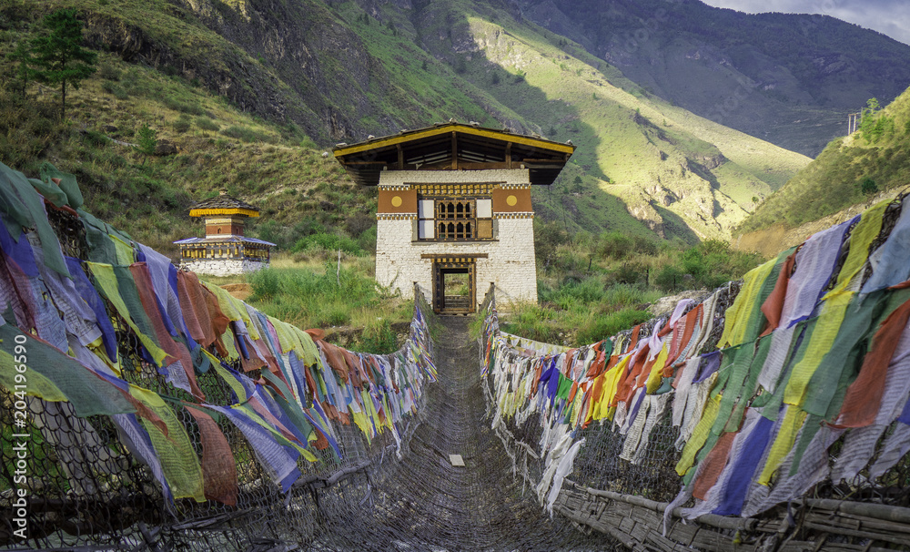 Hanging bridge with colourful Buddhist prayer flags in Paro Bhutan
