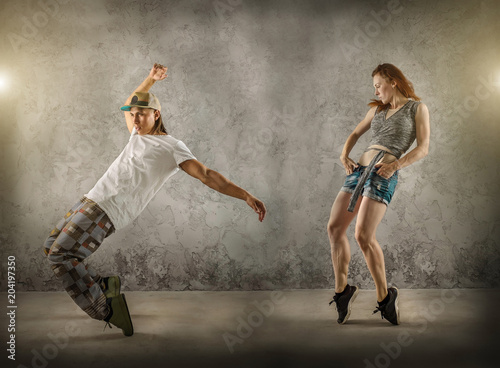 Fototapeta Naklejka Na Ścianę i Meble -  Hip Hop dancer in dynamic action jump on the grunge grey backgro