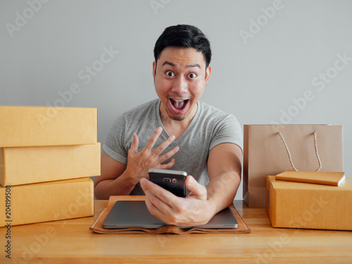 Man is feeling happyand  exciting with his online sales in the smartphone. photo