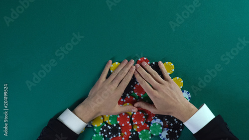Fotografía Winner rejoicing to all chips after poker game, greedy man taking all money