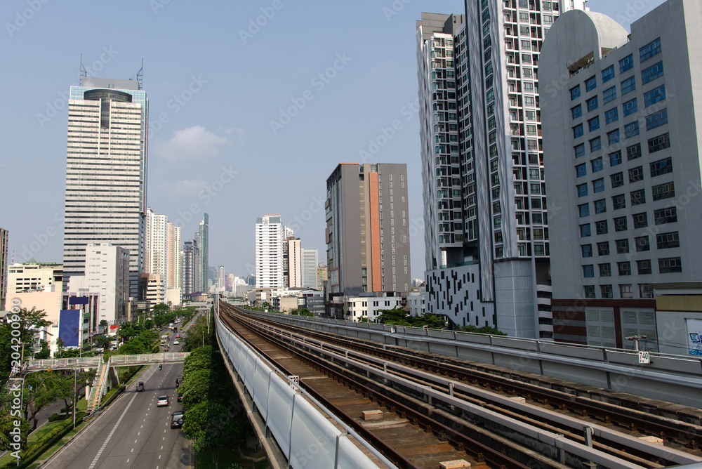 The railway of skytrain leading through the center of the city and surrounded by tall buildings.