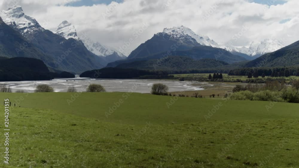 Green grass and alpine mountains, tilting up camera move Green grass and alpine mountains, tilting up camera move