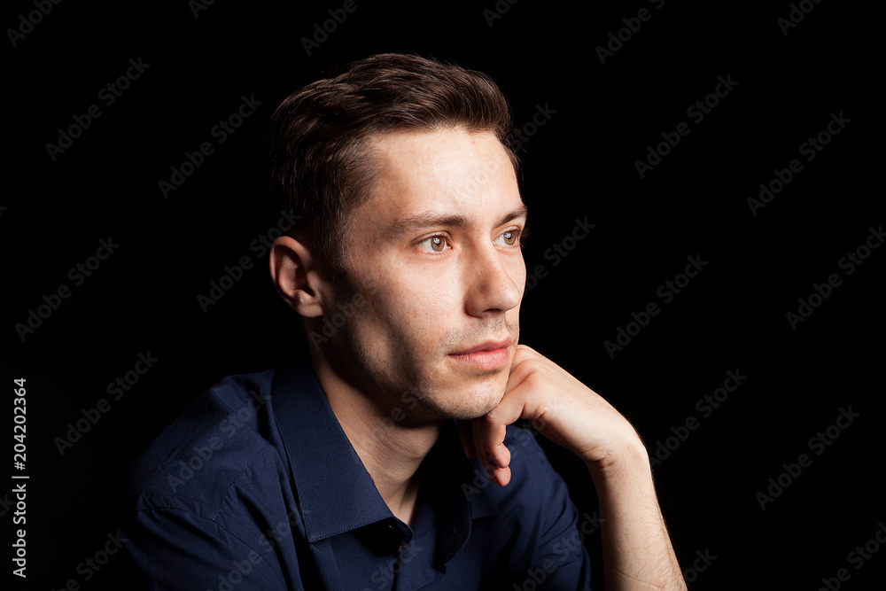 Portrait with fashion lighting of young man on black background