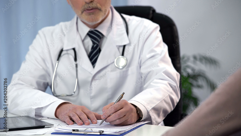 Male therapist filling out registration form and consulting patient, appointment Male therapist filling out registration form and consulting patient, appointment