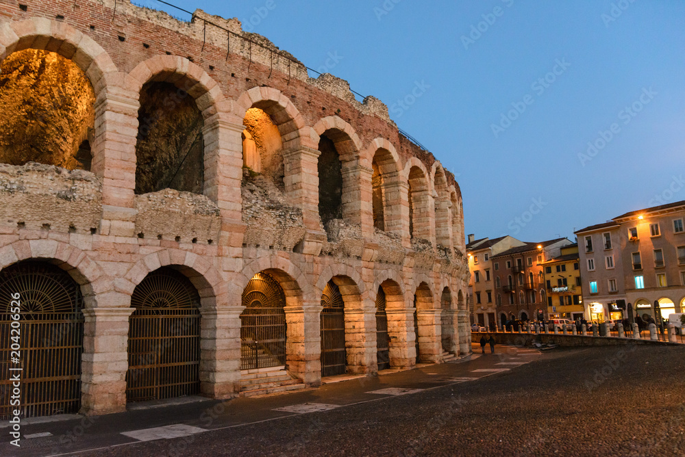 Verona, Italy. Ancient amphitheater Arena di Verona in Italy like Rome Coliseum with nighttime illumination and evening blue sky. Veneto region.