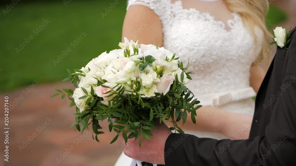 Bride and groom. Groom holding a bouquet. Bride and groom. Groom holding a bouquet.