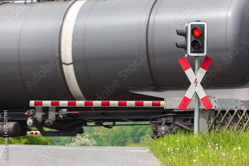 closed railroad crossing with passing cargo train