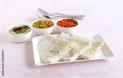 Neer dosa, a south Indian traditional, popular and vegetarian crepe or dish, with coconut and tomato chuntey and vegetable curry as side dishes.