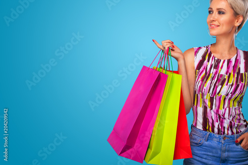 Shopping woman holding color bags isolated on blue background in black friday holiday. Summer shopping sale concept.