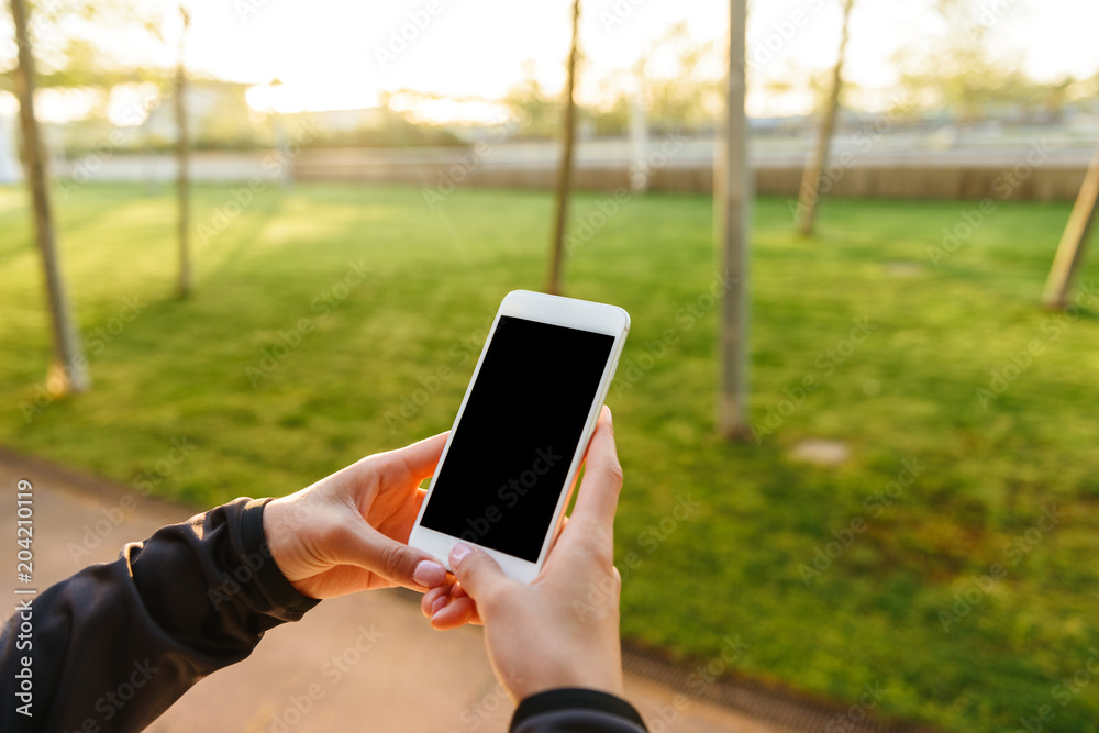 Cropped photo of young sports woman using mobile phone