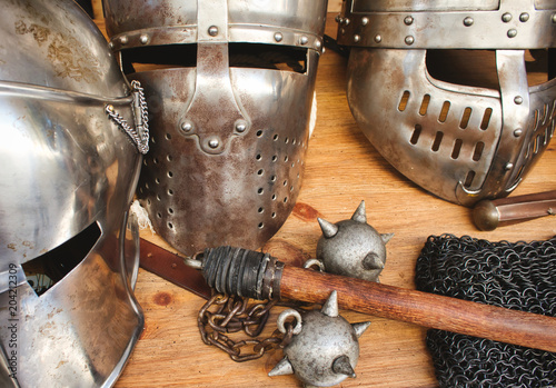 Canvas-taulu Shiny metal helmets of medieval knights with traditional weapons at a middle age