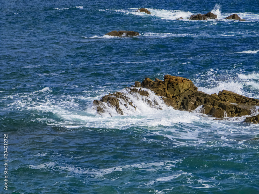 Beautiful rocks at beach with waves and blue water Beautiful rocks at beach with waves and blue water