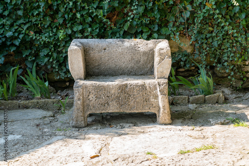 Antique stone bench on a background of ivy wall