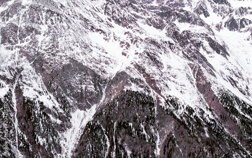 Winter Alpine background. The mountainous terrain in the snow