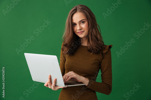 Young cheerful woman holding laptop computer.