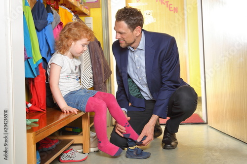 Vater Papa holt Kind Tochter aus Kindergarten photo