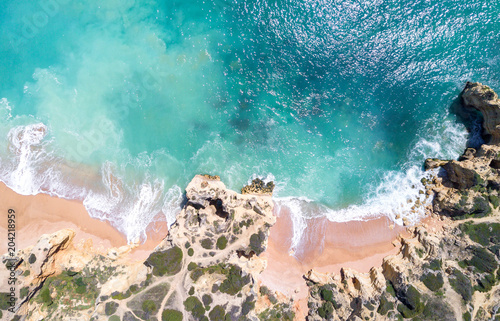 Aerial view of sandy beach and ocean with beautiful clear turquoise water.