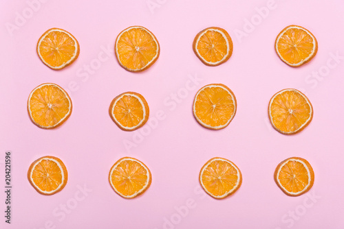 Pieces of orange. Circles with orange. Pink background. Citrus fruits.