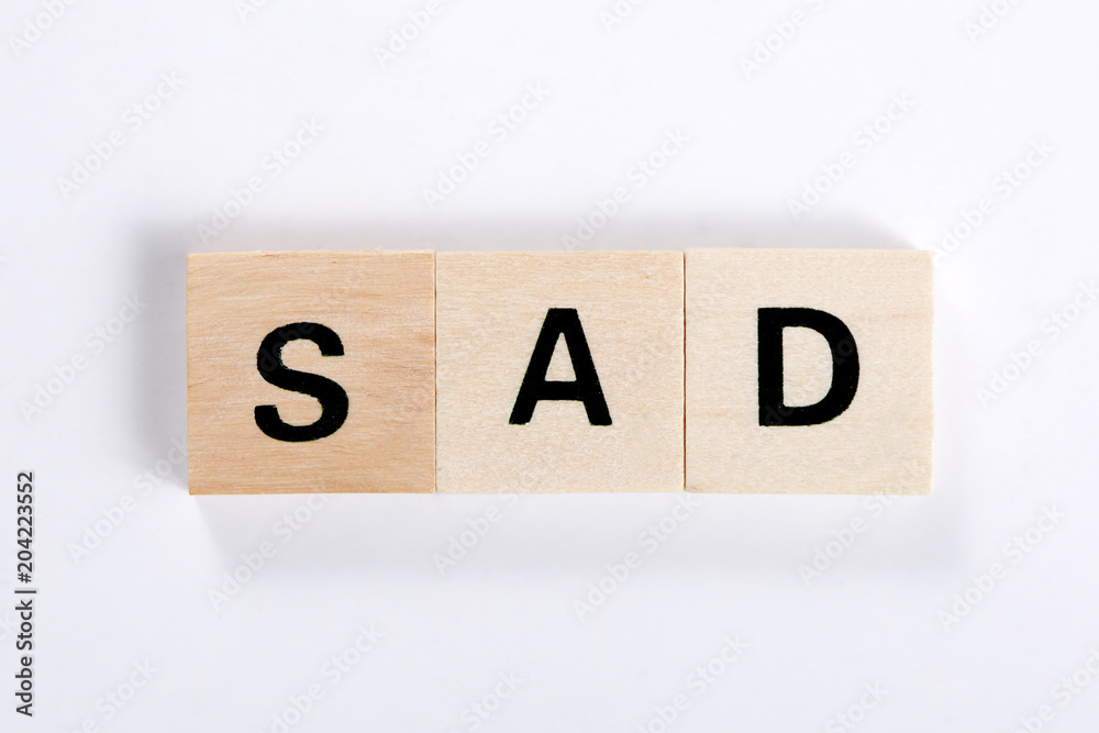 © Andrea - word sad made of wooden block isolated on white background