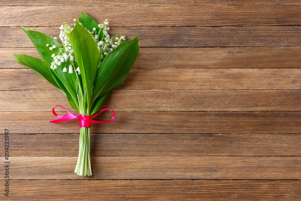 Lily flower bouquet tied with red ribbon on wooden retro background with copy space Lily flower bouquet tied with red ribbon on wooden retro background with copy space