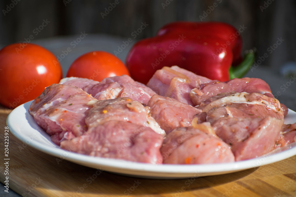 Raw kebab from meat on a wooden board with vegetables