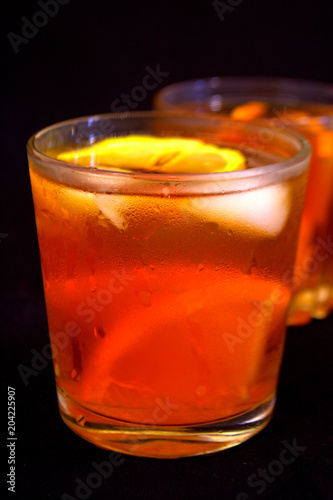 Iced tea with lemon and orange. Refreshment. Black background