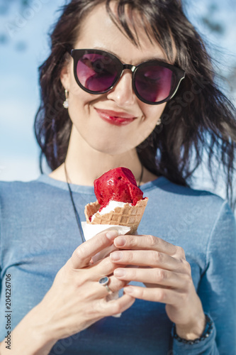 Happy young woman eating ice cream.