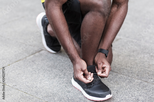 Closeup detail. Man ties up the shoelaces on sneakers before running