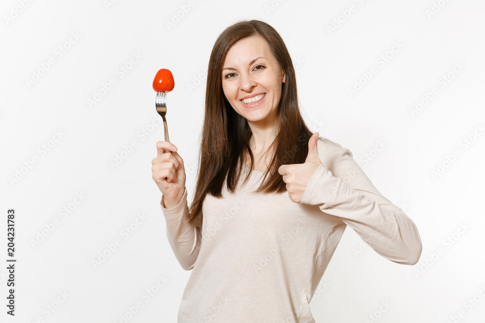Smiling fun vegan woman holds in hand red fresh tomato on fork isolated on white background. Proper nutrition, vegetarian food, healthy lifestyle, vegetable concept. Advertising area with copy space. Smiling fun vegan woman holds in hand red fresh tomato on fork isolated on white background. Proper nutrition, vegetarian food, healthy lifestyle, vegetable concept. Advertising area with copy space.