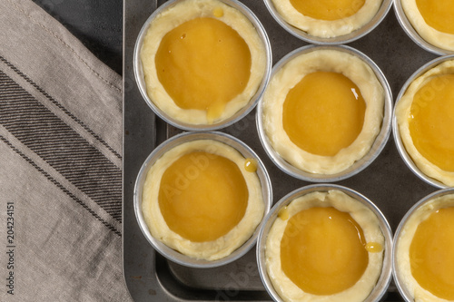 Traditional portuguese dessert pastel de nata before going to the oven. Dough of custard egg tarts