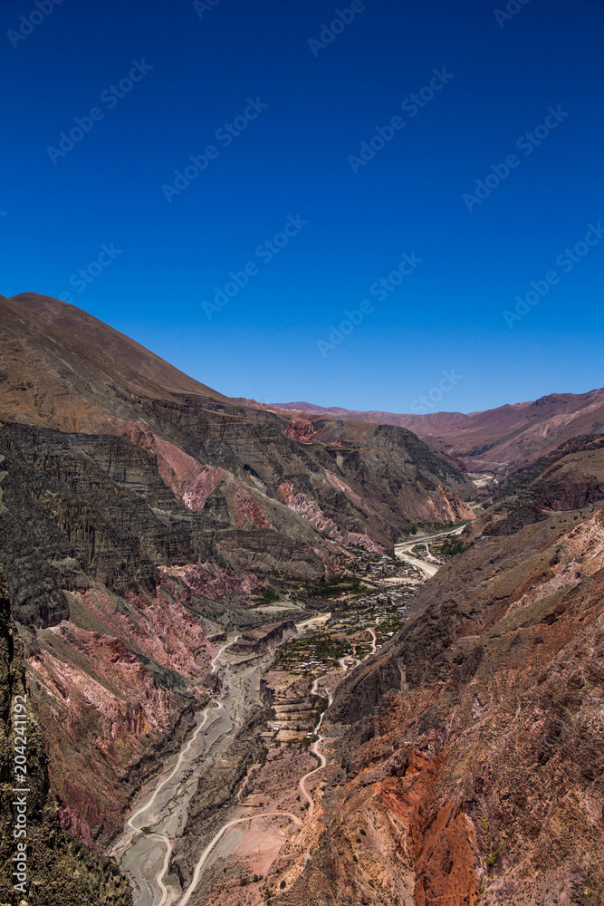 Fototapeta premium View of Iruya village and multicolored mountains in the surroundings at sunset, Salta province, Argentina, iruya - San Isidro - San Juan treeking