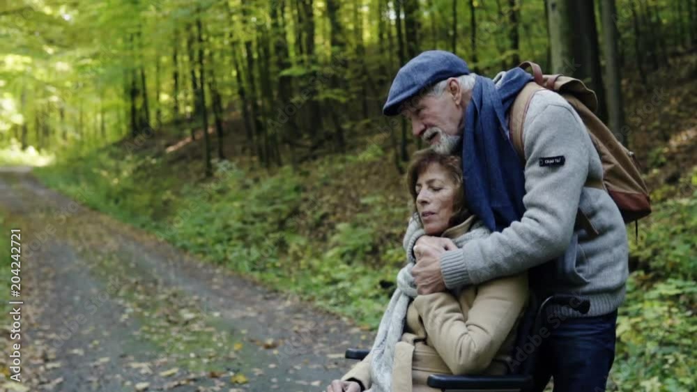 Senior couple with wheelchair in autumn forest. Senior couple with wheelchair in autumn forest.