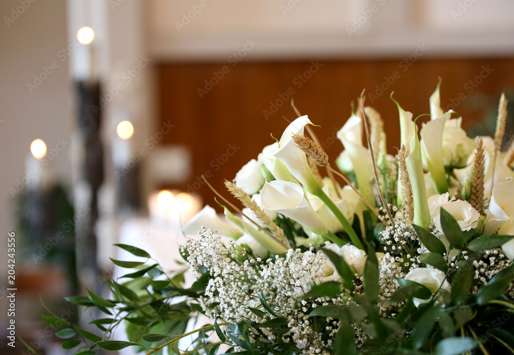 Fototapeta premium kwiaty na ołtarzu w kościele i świece na tle