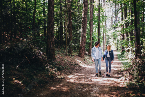 Young couple walking, hand in hand, through forest