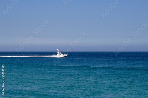 Yacht traveling in the open blue ocean and blue sky in Mexico © Duvy   McGirr