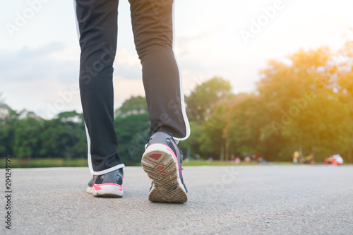 Fototapeta Naklejka Na Ścianę i Meble -  Sporty woman legs walking at public park