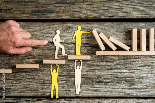 Teamwork and stopping the domino effect concept with paper cutouts of men