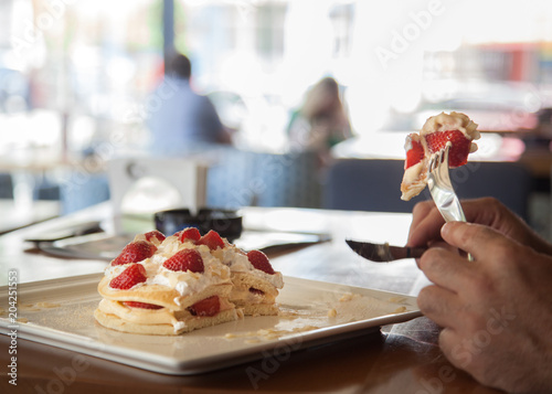 Pancakes with stawberries and cream  the best breakfast for children and adults . Man eats dessert. Healthy eating for lunch . Close-up on the table.Very tasty . Delicious breakfast