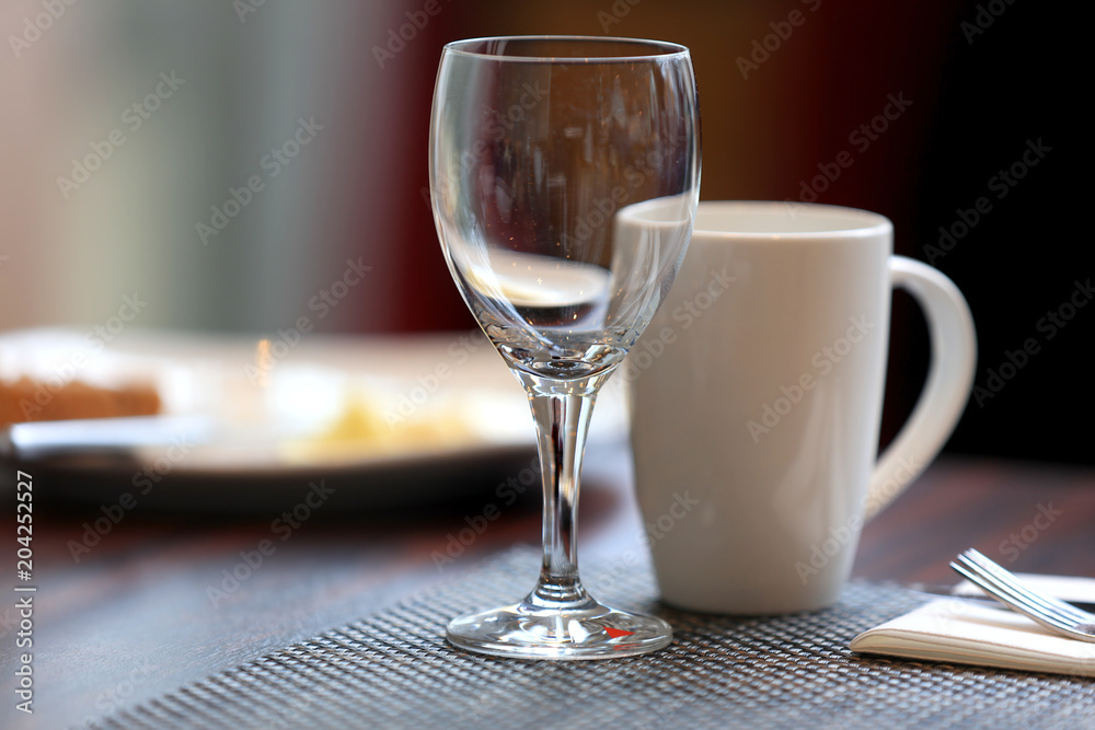 Wine glass and coffee cup on breakfast table Wine glass and coffee cup on breakfast table